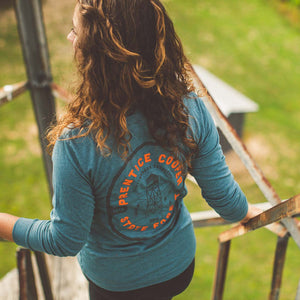 Model wearing Prentice Cooper State Forest long sleeve while climbing a watch tower 