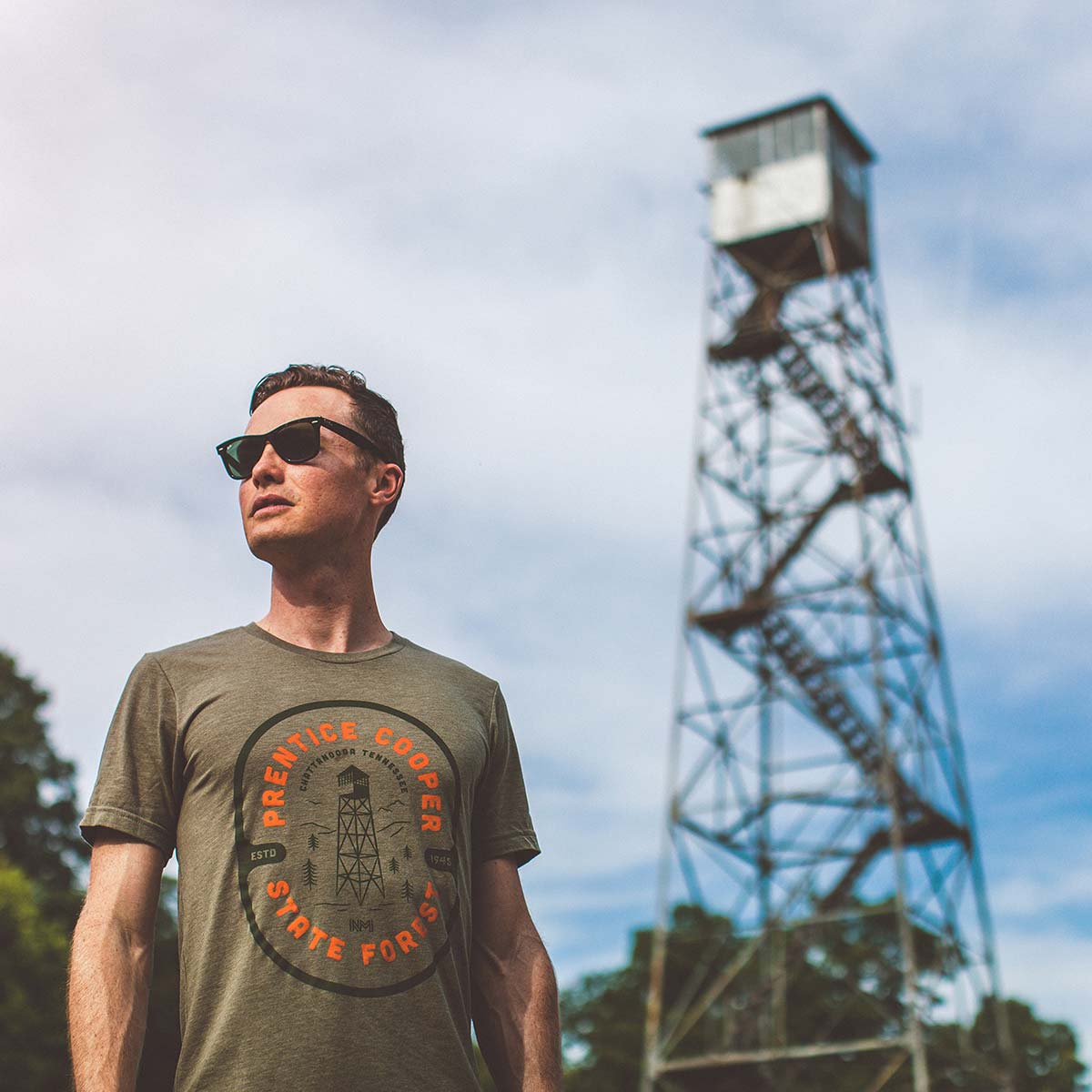 Model wearing the Prentice Cooper State Forest Tee next to a watch tower in Chattanooga Tennessee