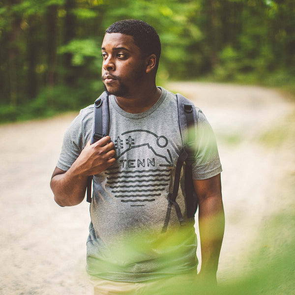 Model wearing Tenn Badge t-shirt in the woods at Prentice Cooper State Forest